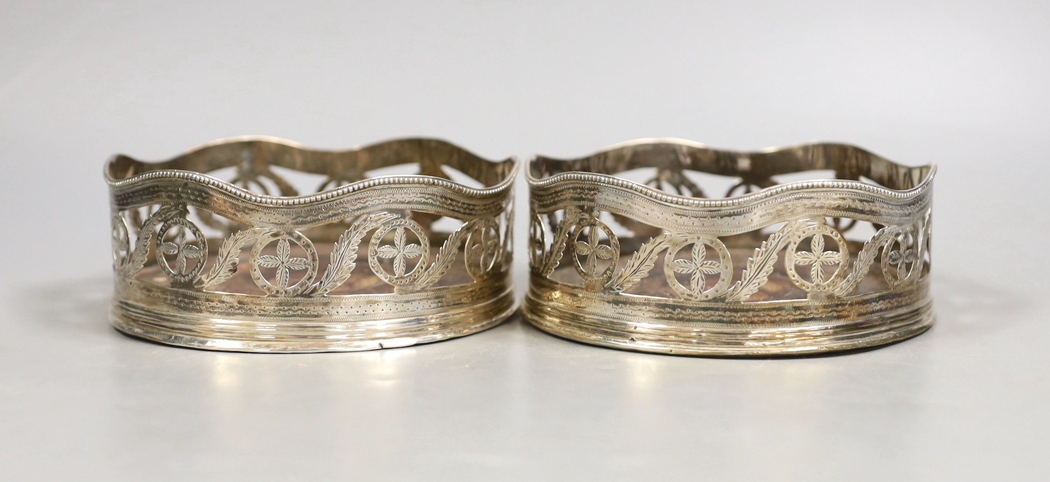 A pair of George III pierced silver wine coasters, maker's mark rubbed, London, 1787,diameter 12.8cm.